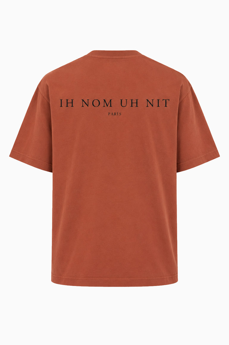 IH NOM UH NIT FW26 rust-brown cotton T-shirt with Mask Jewelry photographic print and applied crystals, decorative stones and pearl-like embellishments, front view.